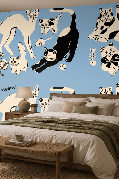 Room scene with pink chair in front of blue wall with black and cream cat wallpaper