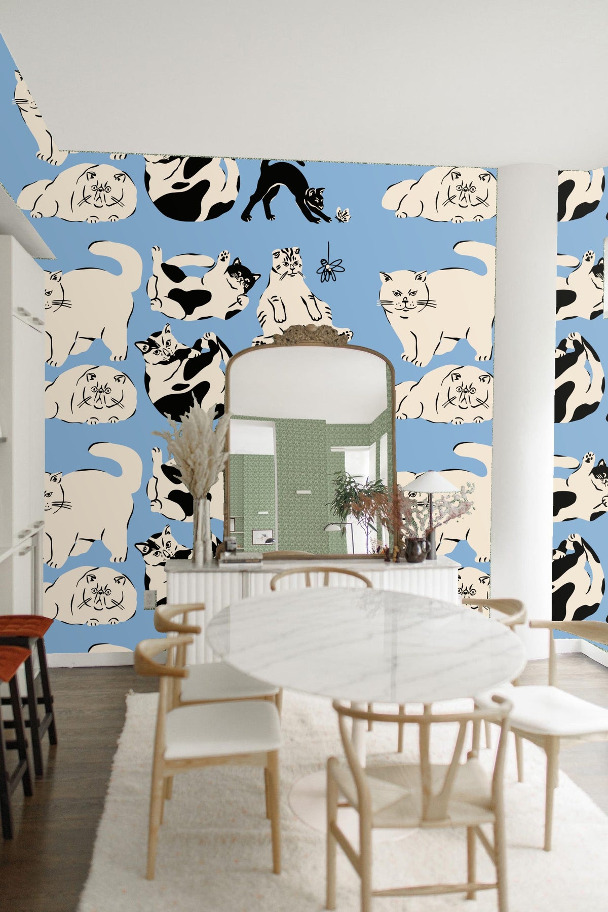 Living room scene with tan sofa and blue wallpaper featuring playful cats pattern