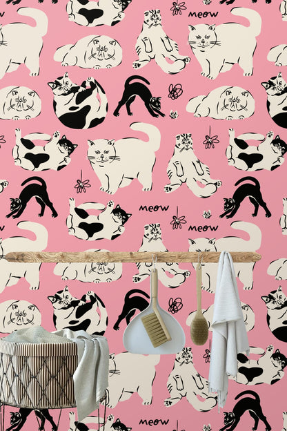 Wall covered in bold pink wallpaper with contrasting detailed cat illustrations