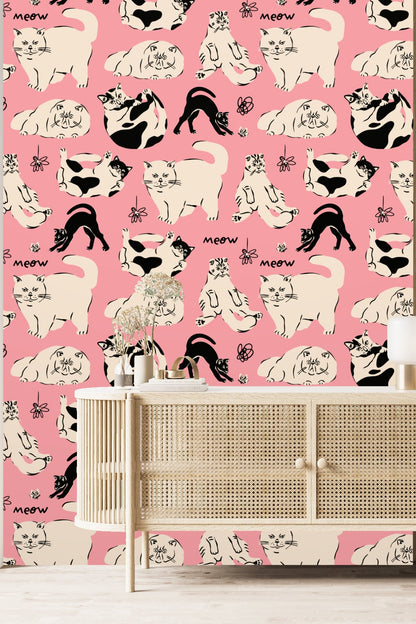 Section of pink wallpaper showing relaxed feline sketches and simple flower doodles
