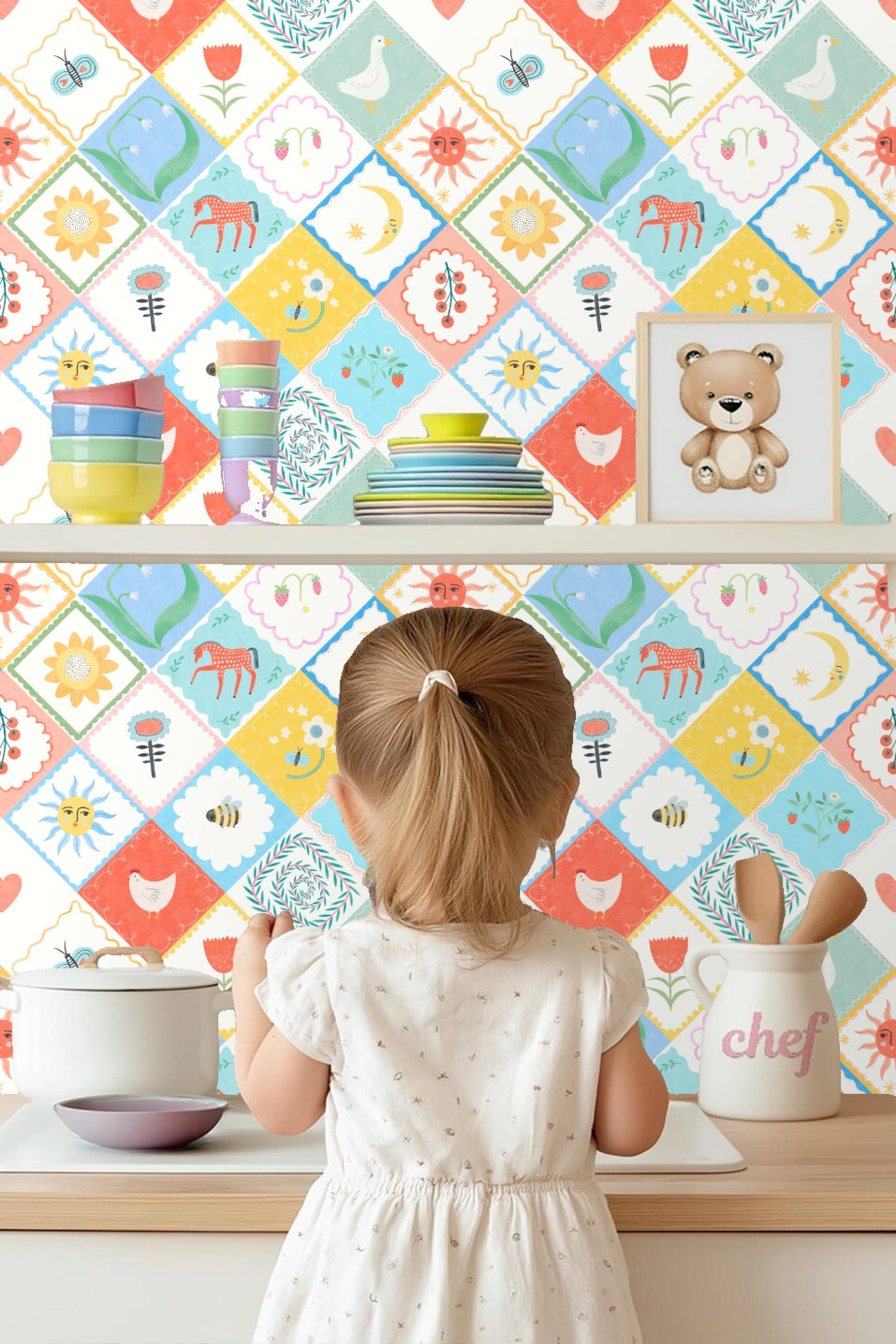 Sun and moon faces with coral and blue backgrounds in patchwork wallpaper