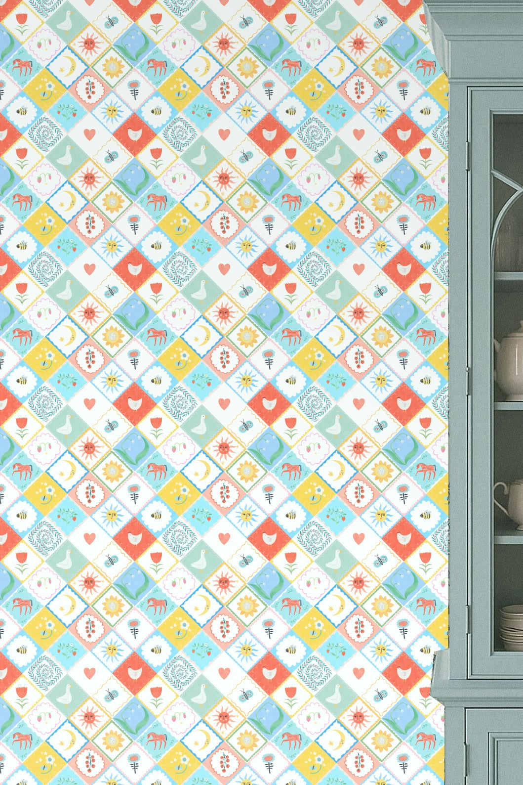 Kitchen wall with Folk Patchplay wallpaper behind blue cabinet