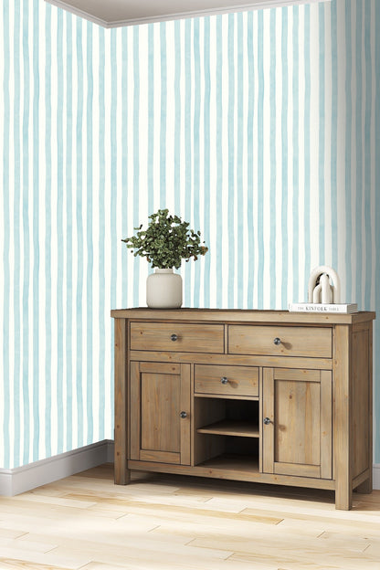 Bedroom wall featuring Rippled Sky Lines wallpaper behind white bedding and minimalist wall lamp