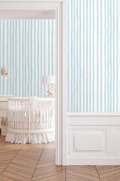 Soft pale blue vertical stripes wallpaper close-up showing hand-painted texture and slight waviness