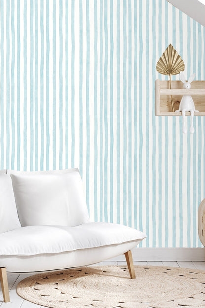 Living room corner with natural wood cabinet and Rippled Sky Lines wallpaper creating a calming backdrop