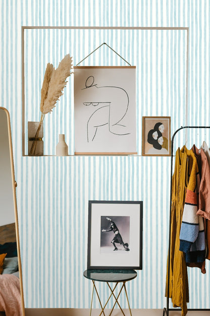 Vertical stripes wallpaper seen behind bedside table with minimalistic reading light