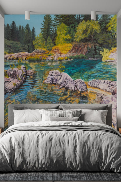 Sunlit rocky riverbank with textured stone formations and patches of grass in wallpaper artwork.