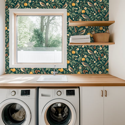 Laundry room view with the botanical wallpaper behind a wood countertop and front-loading washer and dryer