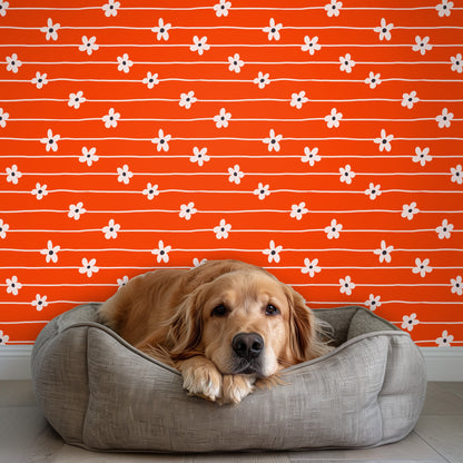 Close-up repeat: hand-drawn wavy cream lines with evenly spaced pale daisies on a saturated orange ground.
