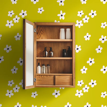 Laundry room with front-load washer and dryer, wood countertop and Citron Bloom wallpaper behind a window and floating shelves.
