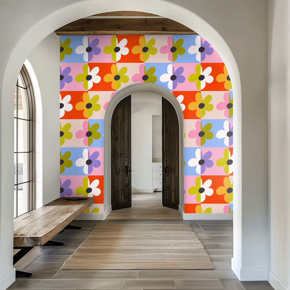 Entryway seen through an arched doorway with the Patchwork Bloom wall creating a colorful, graphic backdrop to rustic doors and a bench.