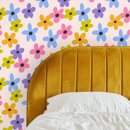 Close-up of Petal Parade pattern showing oversized five-petal flowers in blue, pink, purple, mustard, and chartreuse on a pale blush field.
