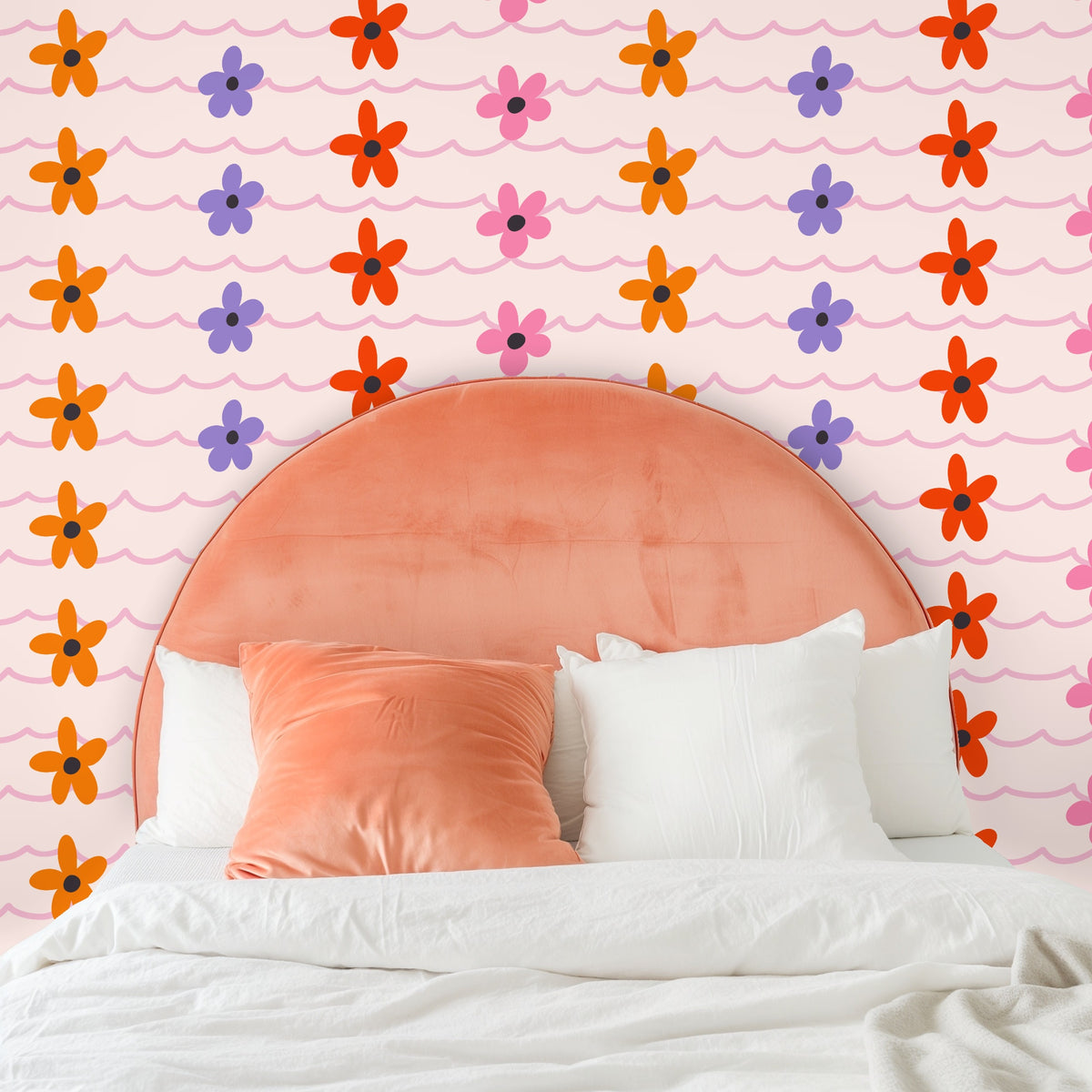 Full-wall view with coral-pink rounded headboard showing how the scalloped rows and flowers scale at bedside