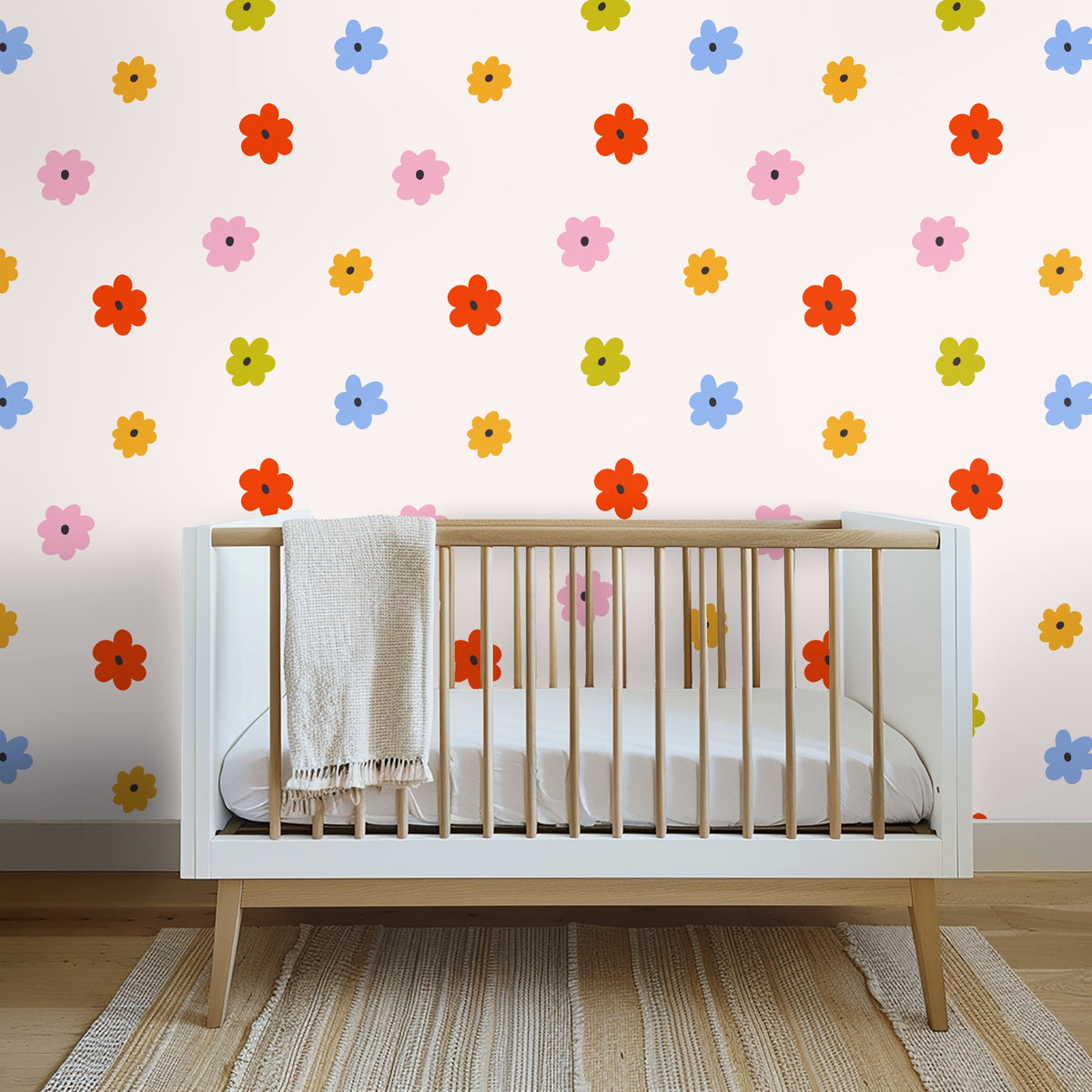 Coral velvet headboard and pillows framed by the scattered posy pattern on a soft blush wall