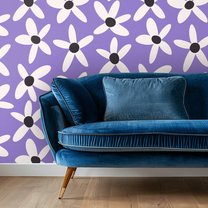 Living room vignette showing Lilac Daisy Parade wallpaper behind a blue velvet sofa