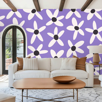 Tabletop vignette with candle and small flowers against the Lilac Daisy Parade wallpaper