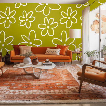 Living room with orange sofa and large-scale chartreuse daisy wallpaper behind it