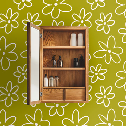 Bathroom medicine cabinet open against a chartreuse daisy wallpaper accent wall