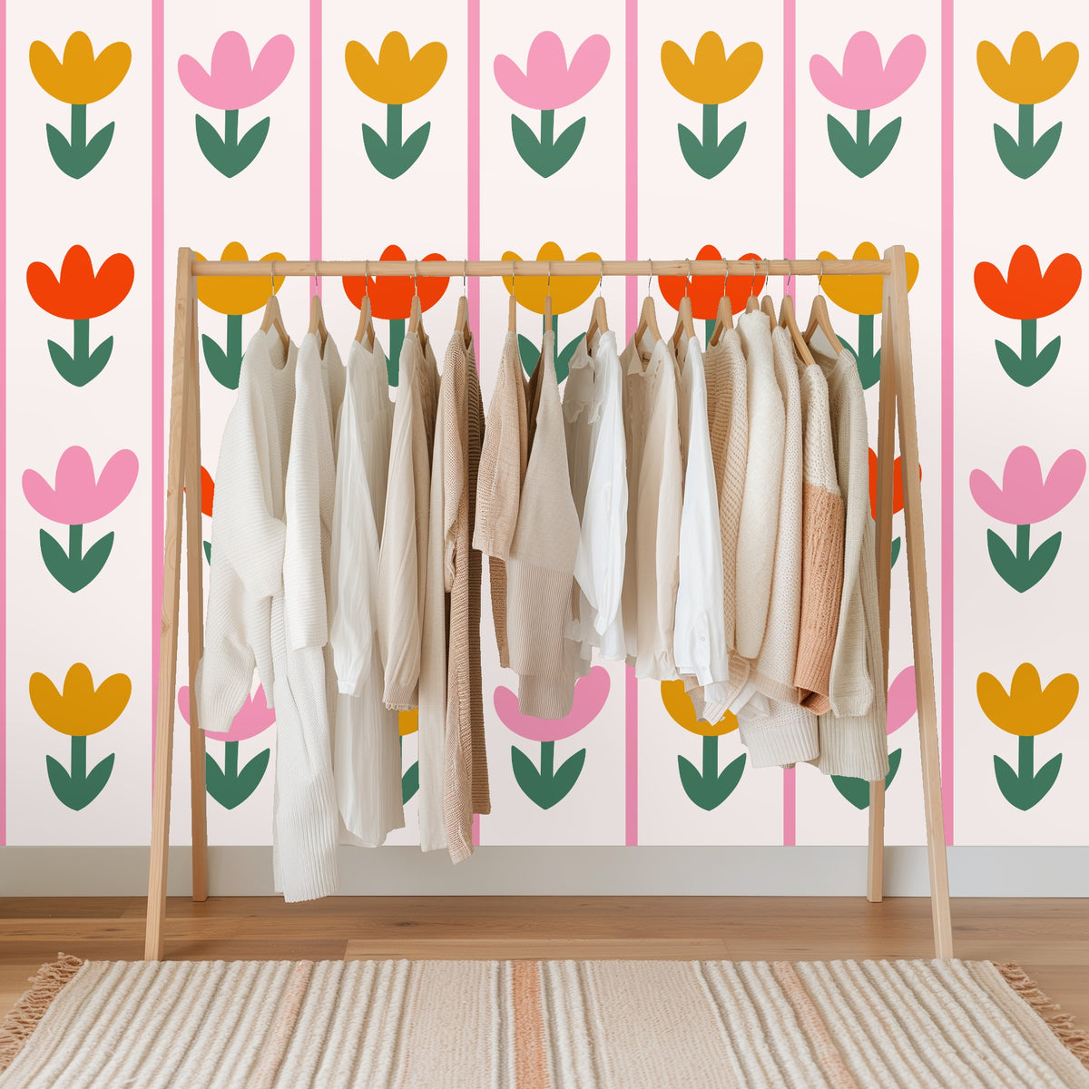 Close view of tulip stems and leaves in deep green contrasting with warm floral colors on the wallpaper