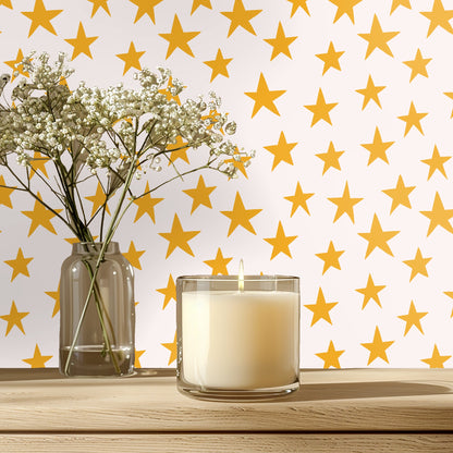 Rounded peach headboard in front of a full-wall star pattern showing the wallpaper at life-size scale.