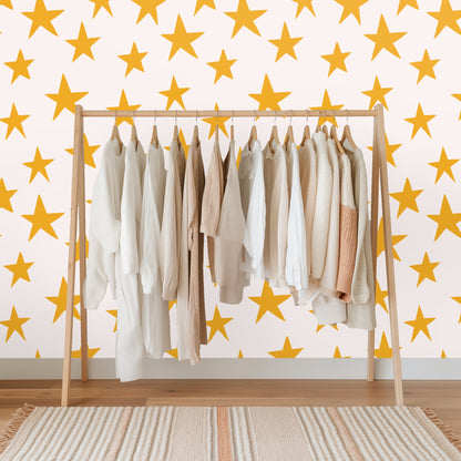 Wide wall view demonstrating the consistent repeat and medium spacing of mustard stars across the blush surface.