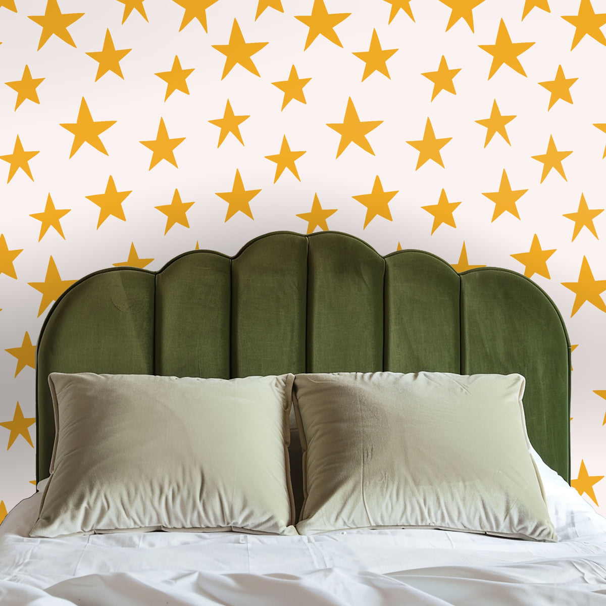 Light-wood dresser topped by a round mirror, the star wallpaper as a warm, graphic backdrop.