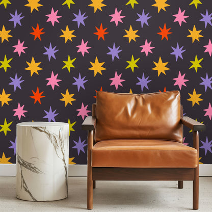 Bedroom headboard wall with Nocturne Starburst pattern behind green velvet headboard