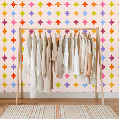 Decorative wooden blanket ladder leaning against a wall covered with the multi-colored lozenge star wallpaper