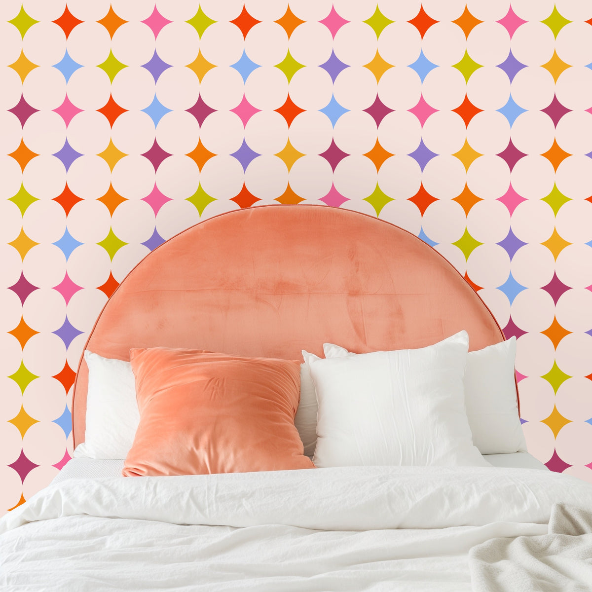 Wide shot of a living room showing a large wall dressed in the repeating colorful star pattern and warm, terracotta accents