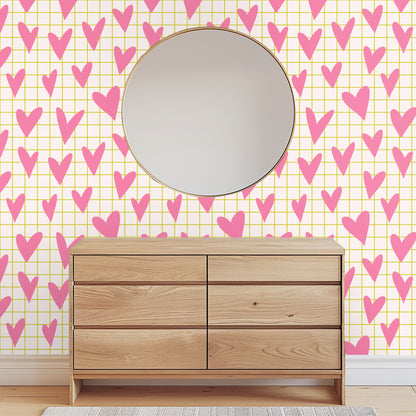 Close-up of pattern artwork showing bubblegum pink hand-drawn hearts over a pale cream background with a thin mustard grid.
