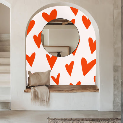 Cozy living area with cream sofa and bold heart wallpaper in the background.
