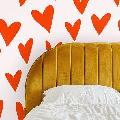 Close-up crop of large hand-drawn orange hearts on a pale blush background.
