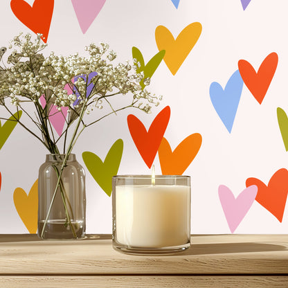 Bedroom vignette with a coral velvet headboard set against the Sweetheart Scatter mural of colorful hearts on a soft blush background