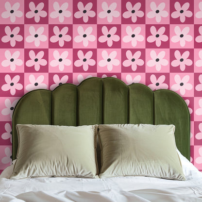 Console table vignette with framed art and lamp in front of the pink gridflower wallpaper.