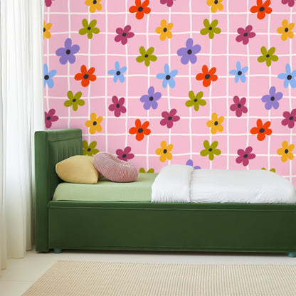 Close view of the wallpaper behind a bedside vignette with a lit candle and small glass vase, showing pattern scale and color.
