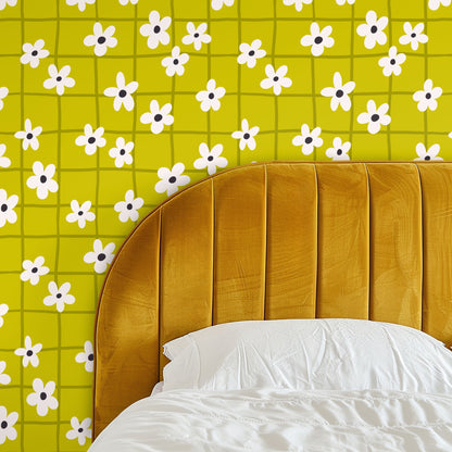 Close-up of wallpaper: bright chartreuse background with olive hand-drawn grid and cream five-petal flowers with dark centers