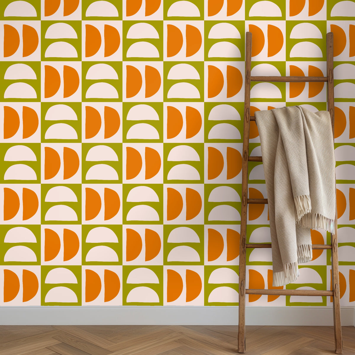 Wooden ladder leaning against a wall covered in Quartermoon Grid wallpaper with a neutral throw draped over a rung.