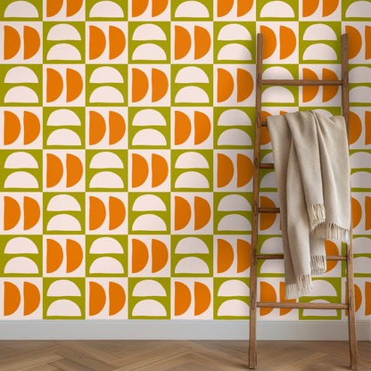 Wooden ladder leaning against a wall covered in Quartermoon Grid wallpaper with a neutral throw draped over a rung.