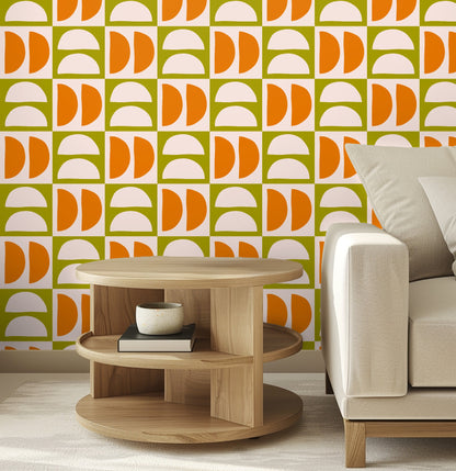 Full-wall view of the tiled repeat: blush semicircles and tangerine half-disks on olive squares across a room wall.