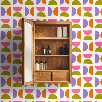 Open wooden medicine cabinet mounted on the patterned wall, showing alignment of the small repeat around bathroom fixtures.