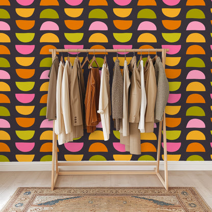 Close crop of wallpaper in a bathroom setting with a brass towel ring and marble sink edge visible beside the pattern.