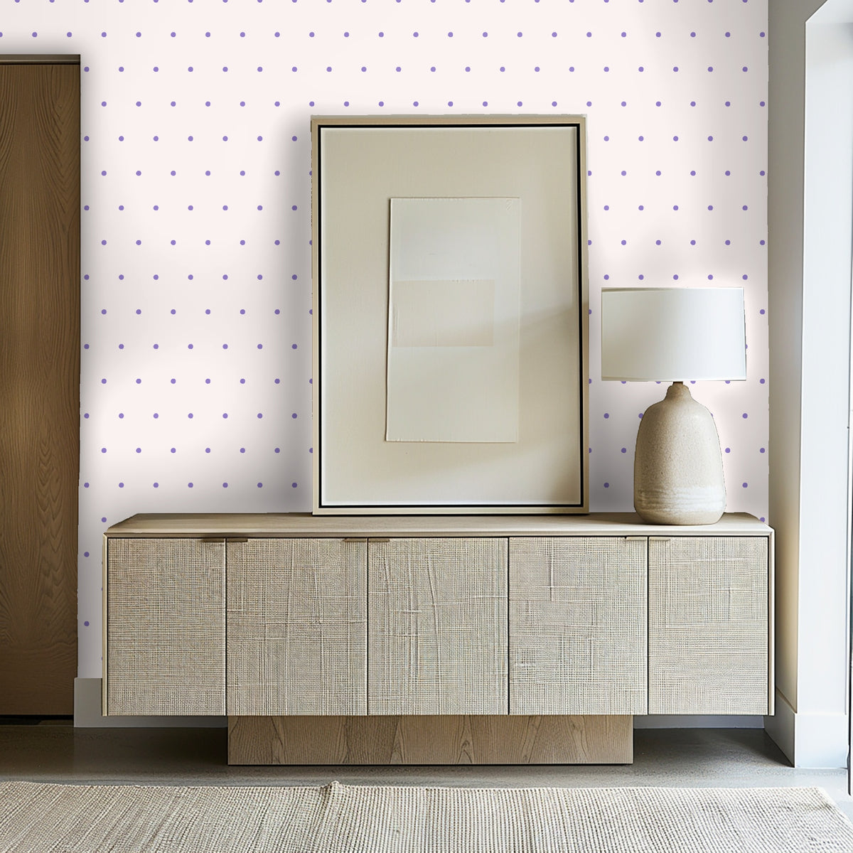 Entryway console styled against the wallpaper with framed art and a ceramic lamp