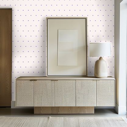 Entryway console styled against the wallpaper with framed art and a ceramic lamp