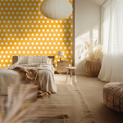 Bedroom mockup with a marigold polka-dot accent wall behind a neutral bed and woven textures.