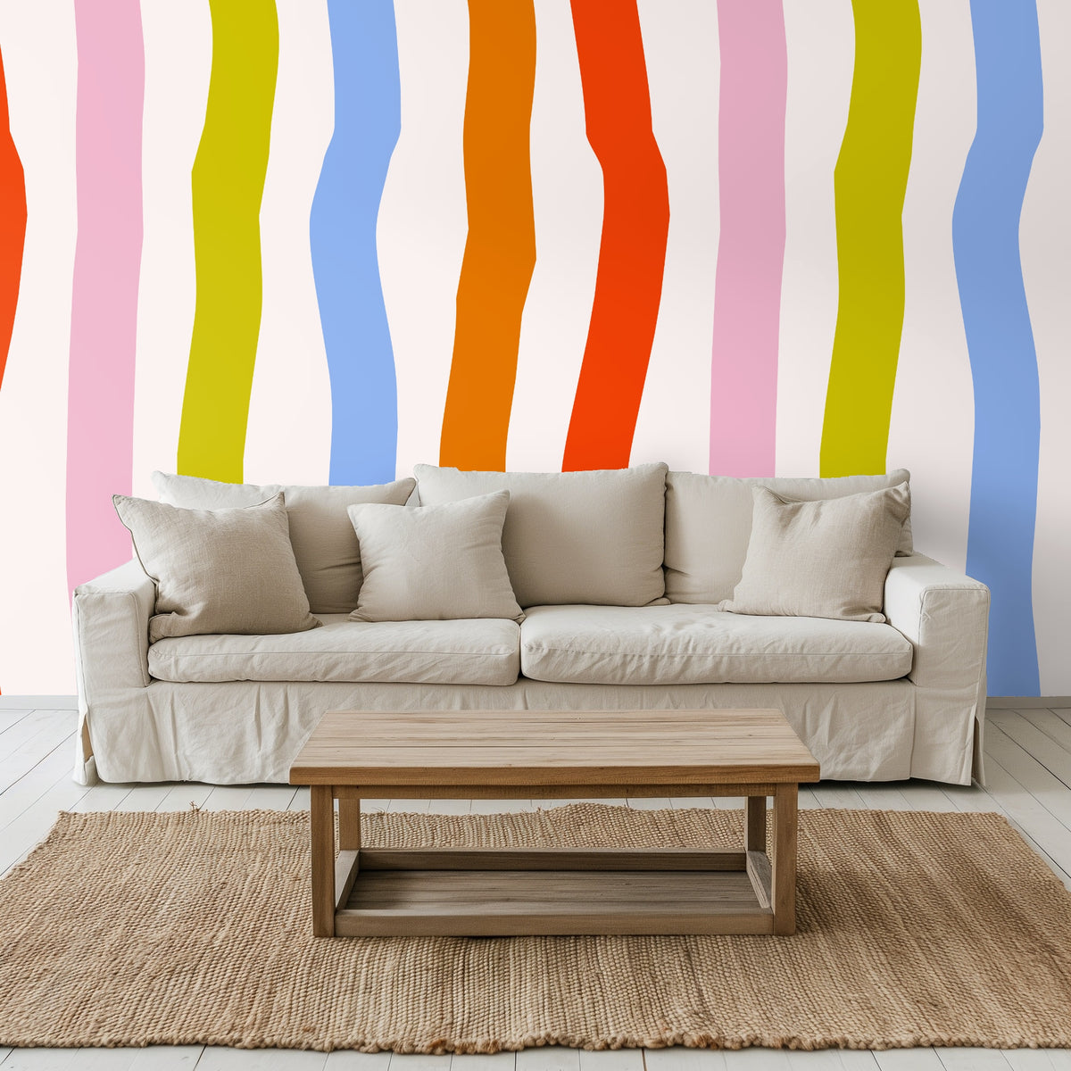 Neutral living room sofa against an accent wall with oversized undulating vertical stripes in bright, painterly colors