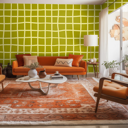 Living room vignette with orange sofa and rug against a full Vireo Lattice accent wall in chartreuse and olive.