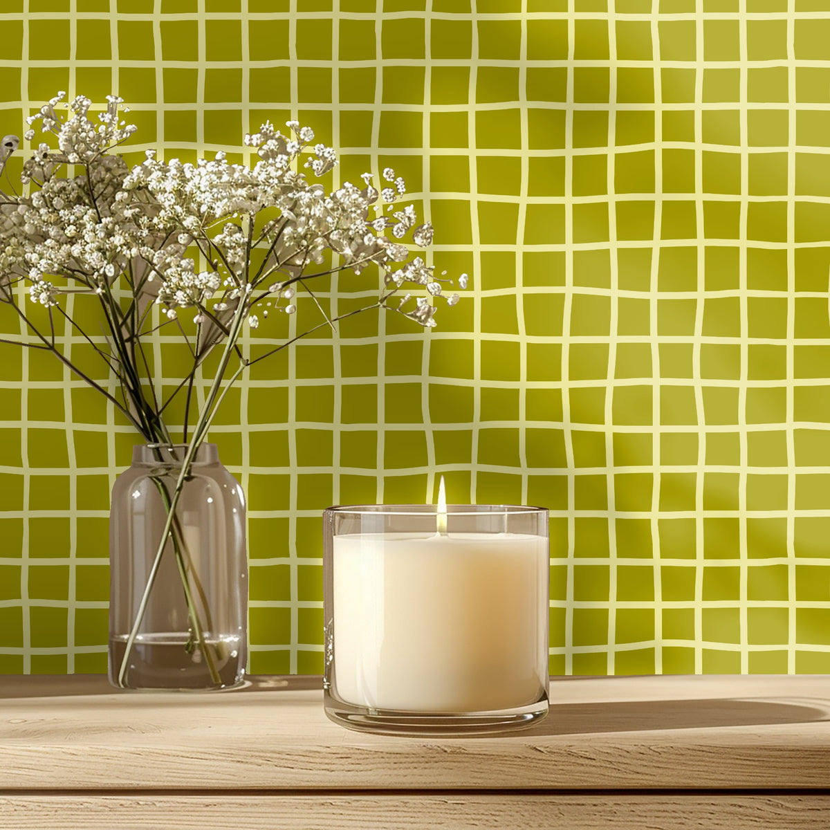Tabletop vignette with lit candle and delicate flowers placed before the Vireo Lattice pattern.