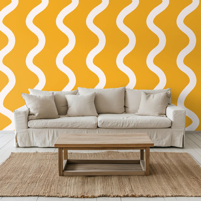 Living room view with a neutral sofa placed against the saffron and cream wavy stripe wallpaper