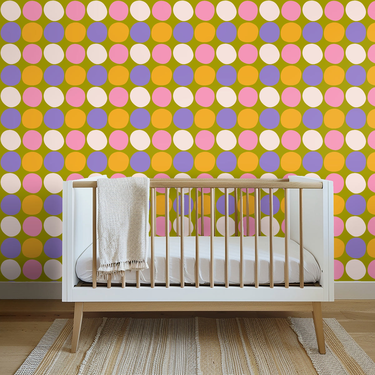Nursery scene with white crib in front of the colorful polka wallpaper creating a lively backdrop