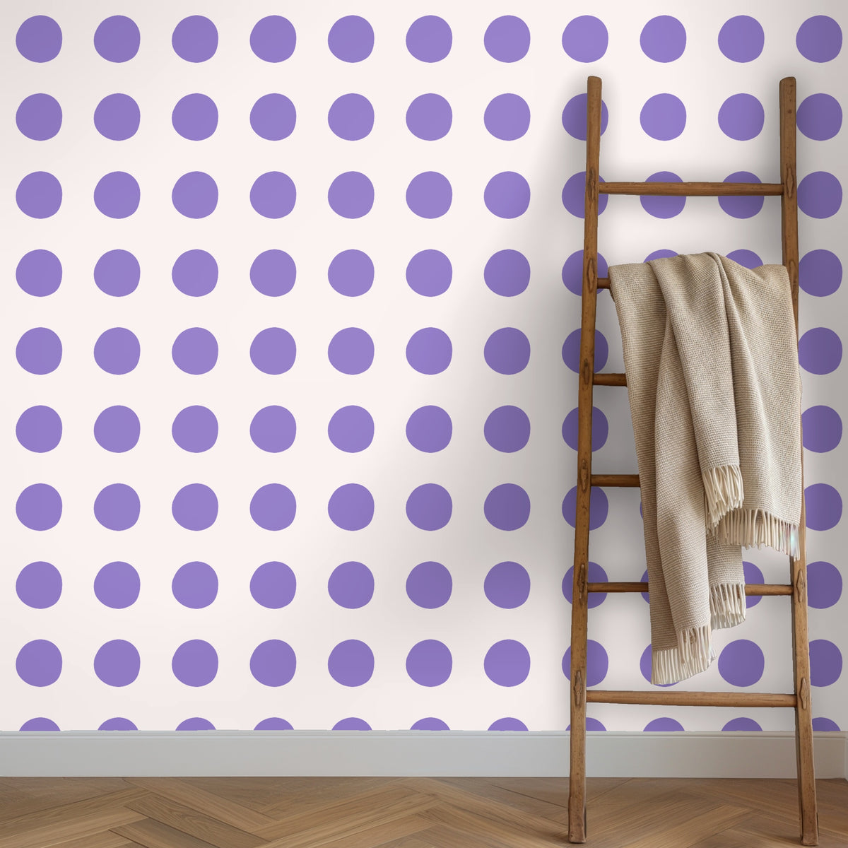 Clothing rack and garments in front of a polka dot wallpapered wall in lavender and blush
